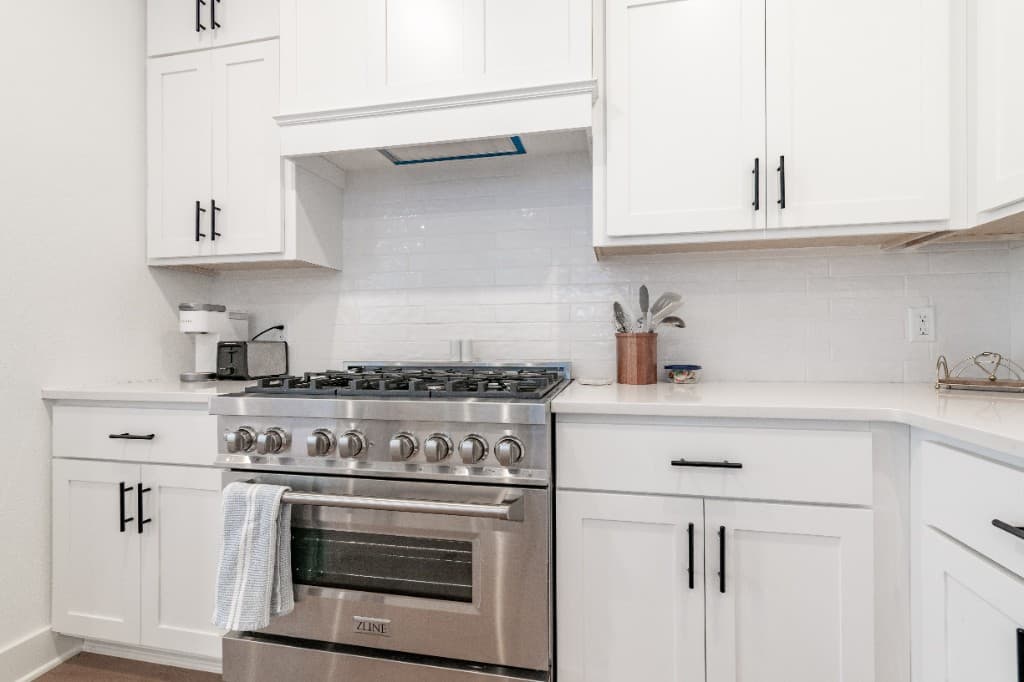 Deans Row Avenue — professional gas range and white cabinetry