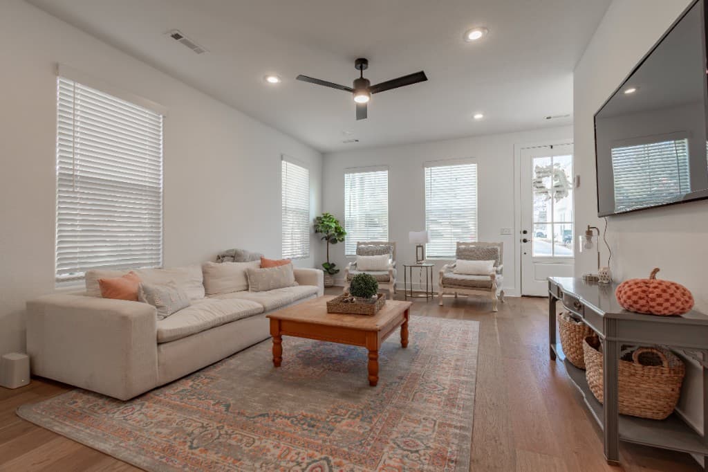 Deans Row Avenue — living room with sofa, patterned rug, and windows